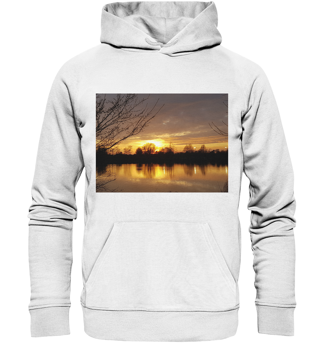 Der Abendspaziergang - Organic Basic Hoodie von Silbers Magic Shop ist ein hellgraues Stück aus Bio-Baumwolle und zeigt ein lebendiges Bild eines Sonnenuntergangs über einem ruhigen See. Die goldenen und orangen Farbtöne des Sonnenuntergangs spiegeln sich im Wasser, mit Silhouetten von Bäumen am Horizont. Äste rahmen die Szene ein und verleihen der ruhigen Landschaft auf diesem Hoodie eine natürliche Note.