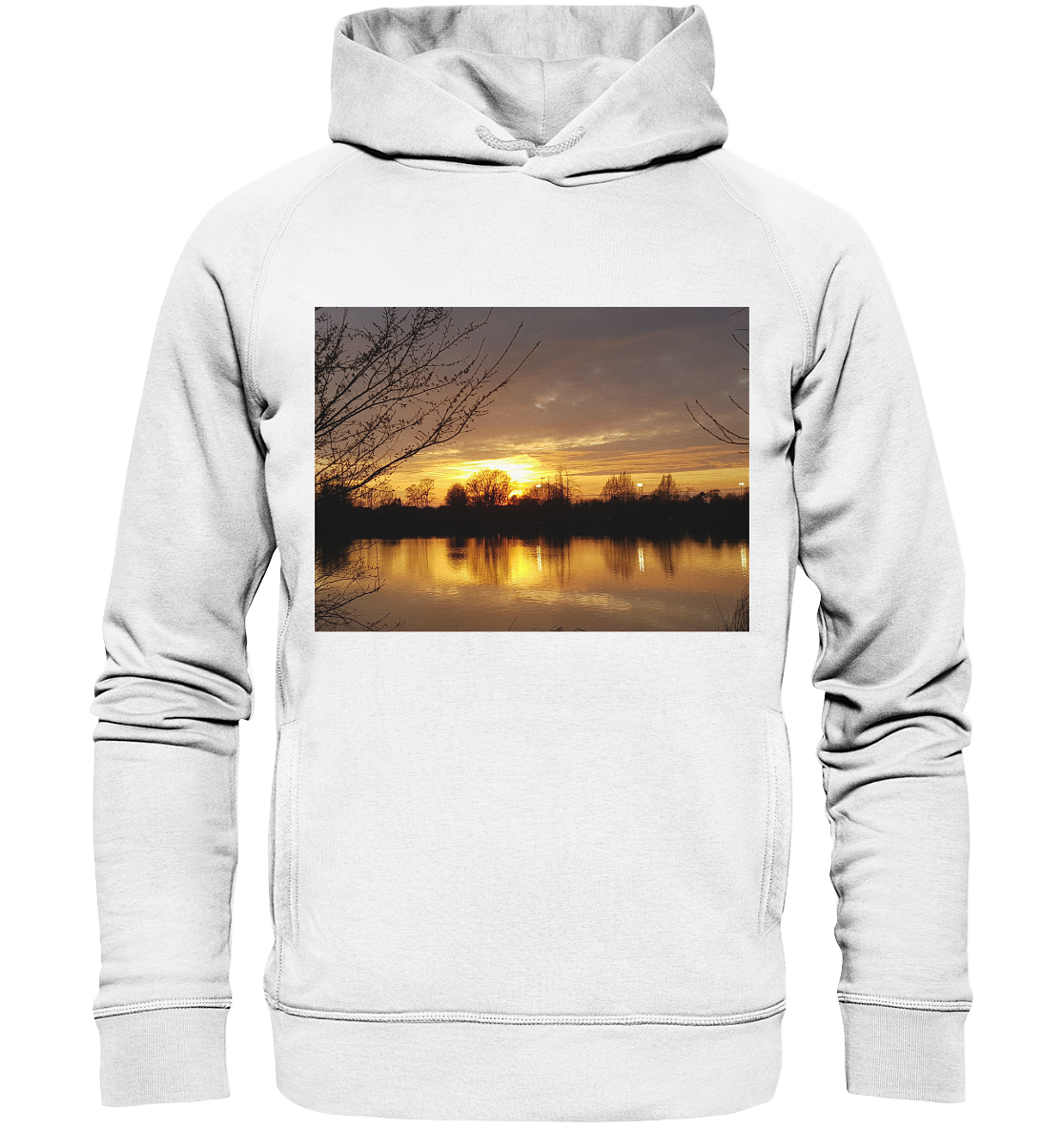 Der Abendspaziergang - Organic Fashion Hoodie von Silbers Magic Shop zeigt ein ruhiges Bild eines Sonnenuntergangs über einem See. Die Sonne geht hinter den Silhouetten der Bäume unter und wirft einen orange-gelben Schein über das Wasser. Kahle Äste rahmen die Szene auf der linken und rechten Seite ein. Genießen Sie die Schönheit der Natur mit unserem nachhaltigen Design in Hellgrau.