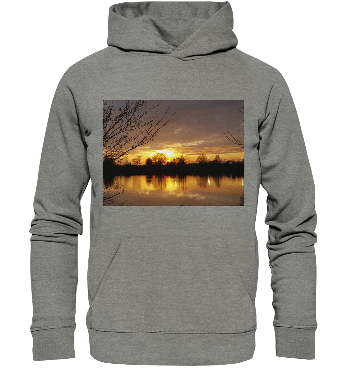 Der „Abendspaziergang - Organic Hoodie“ von Silbers Magic Shop zeigt einen lebhaften Sonnenuntergangsdruck über einem ruhigen See. Der Himmel vermischt orangefarbene, gelbe und rosa Farbtöne, mit Baumsilhouetten am Horizont, deren Spiegelbilder im ruhigen Wasser schimmern. Äste rahmen die Szene auf beiden Seiten ein, alles aus nachhaltig produzierter Bio-Baumwolle.