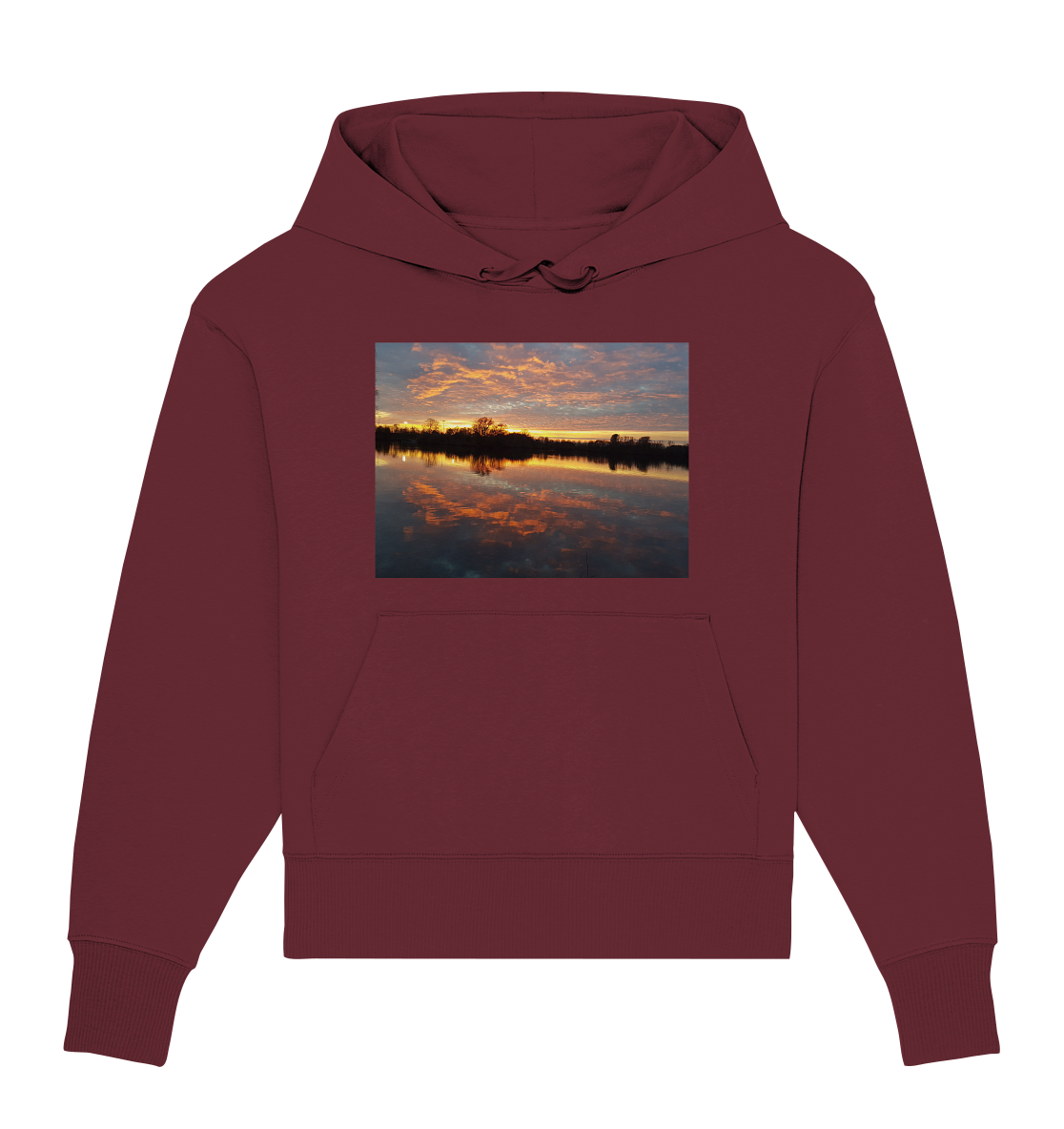 Der See am Abend - Organic Oversize Hoodie von Silbers Magic Shop ist ein kastanienbraunes Kapuzensweatshirt aus Bio-Baumwolle. Es zeigt ein farbenfrohes Bild eines Sonnenuntergangs über einem See, mit leuchtenden Orange- und Gelbtönen, die sich im ruhigen Wasser spiegeln, und den Silhouetten der Bäume im Hintergrund. Für zusätzlichen Komfort verfügt dieser Hoodie über Kordelzüge und eine Vordertasche.