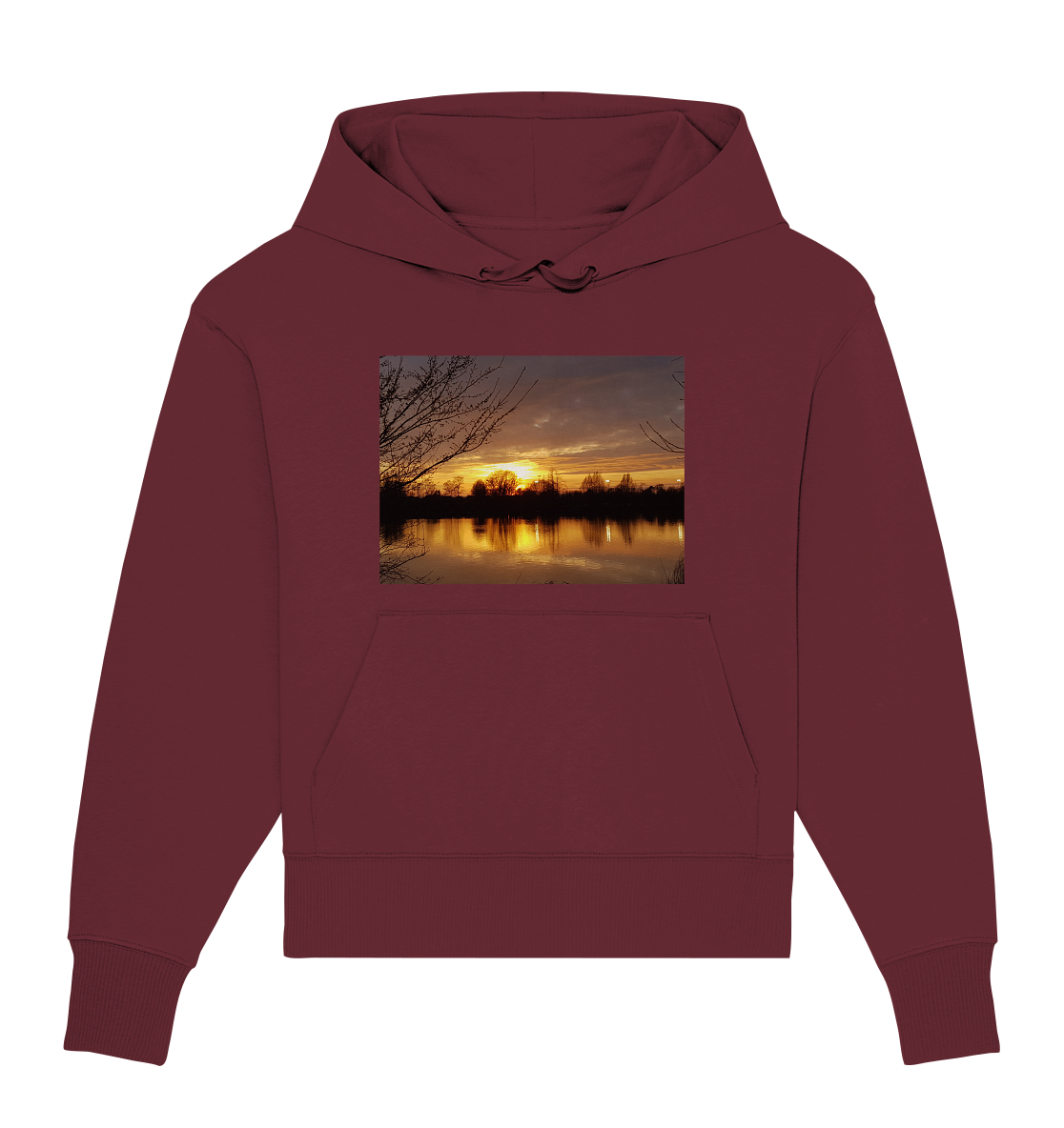 Der Abendspaziergang - Organic Oversize Hoodie von Silbers Magic Shop ist ein kastanienbrauner Unisex-Hoodie, der ein lebendiges Bild eines Sonnenuntergangs über einem ruhigen See zeigt, umrahmt von Baumsilhouetten. Der Himmel ist in warmen Orange- und Gelbtönen gemalt, die sich im stillen Wasser darunter spiegeln. Dieser aus Bio-Baumwolle gefertigte Hoodie bietet sowohl Komfort als auch Nachhaltigkeit.