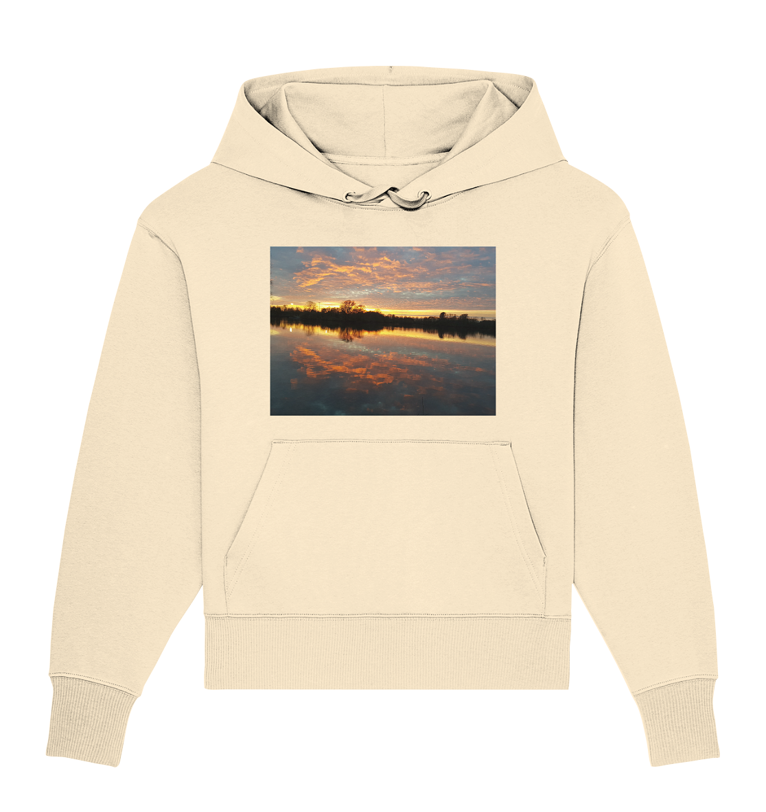 Der See am Abend - Organic Oversize Hoodie von Silbers Magic Shop ist ein beigefarbener, übergroßer Hoodie mit einer Vordertasche und einer Kapuze mit Kordelzug. Auf der Brust ist ein Bild zu sehen, das einen ruhigen Sonnenuntergang über dem Wasser zeigt, komplett mit einer Baumsilhouette und leuchtenden Reflexen in Orange- und Rosatönen. Hergestellt aus Bio-Baumwolle für zusätzliche Nachhaltigkeit.