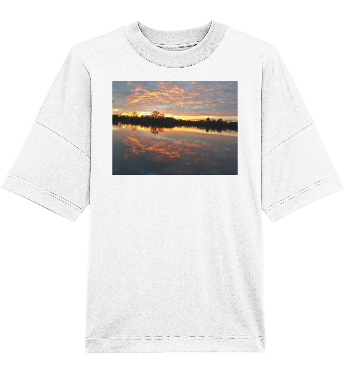 Das See am Abend - Organic Oversize Shirt von Silbers Magic Shop ist ein weißes Unisex-T-Shirt, das ein lebendiges Bild eines ruhigen Sees bei Sonnenuntergang zeigt. Der Himmel zeigt orangefarbene und rosa Farbtöne, während das ruhige Wasser den Himmel und die Baumsilhouetten am Horizont perfekt widerspiegelt. Dieses Shirt aus Bio-Baumwolle verbindet auf elegante Weise Nachhaltigkeit mit Stil.