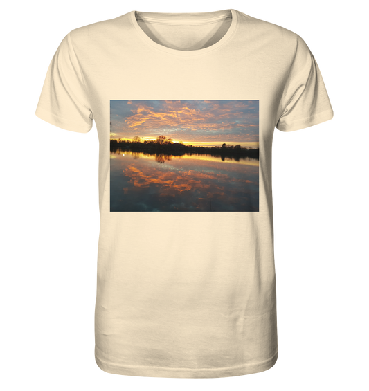 Das See am Abend - Organic Shirt von Silbers Magic Shop zeigt einen malerischen Sonnenuntergang über einem ruhigen See mit orangefarbenen und rosa Wolken, die sich im Wasser spiegeln. Eine Baumsilhouette am Horizont vervollständigt dieses ruhige Design, das für nachhaltige Herstellung und einzigartiges Design steht.